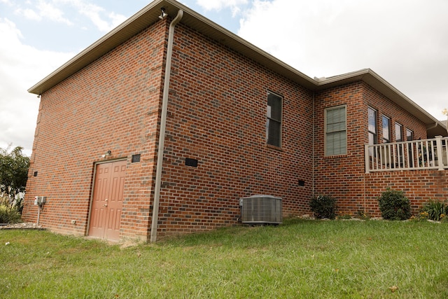 view of side of home featuring central air condition unit and a lawn