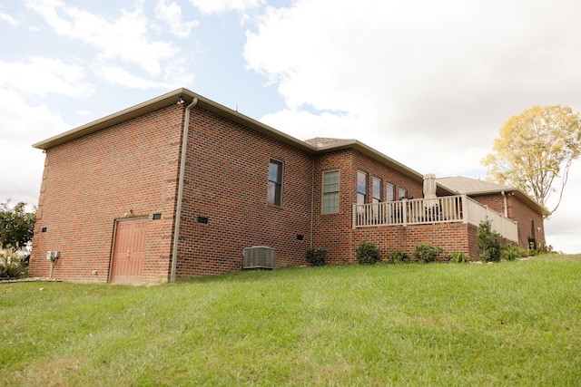 view of side of property with central AC and a yard