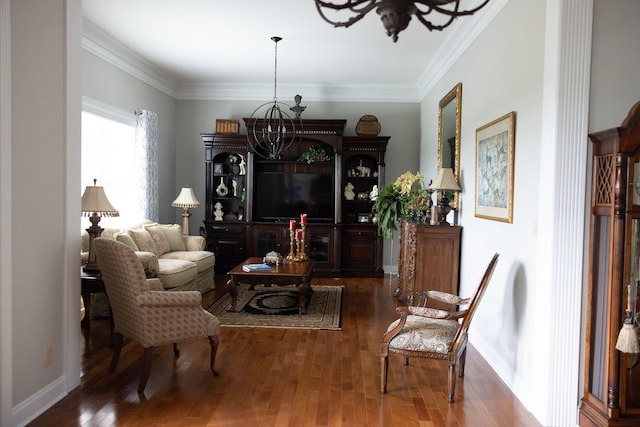 sitting room with an inviting chandelier, crown molding, and dark wood-type flooring