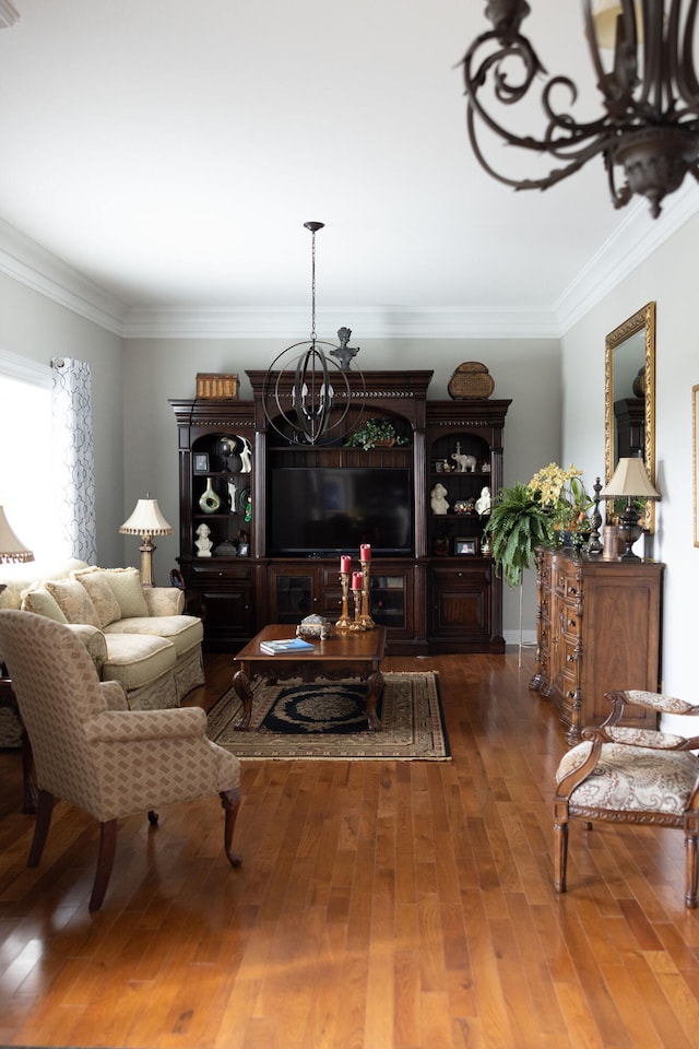 living room with ornamental molding, an inviting chandelier, and dark hardwood / wood-style floors