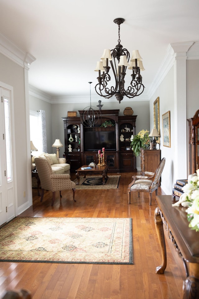 living room with ornamental molding, hardwood / wood-style flooring, a chandelier, and decorative columns