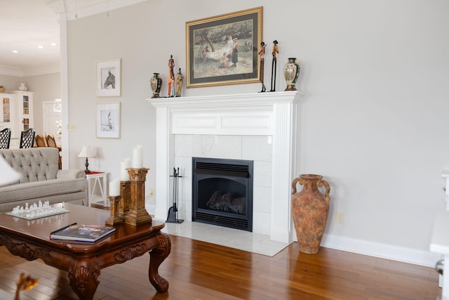 living room with ornamental molding, a fireplace, and hardwood / wood-style flooring