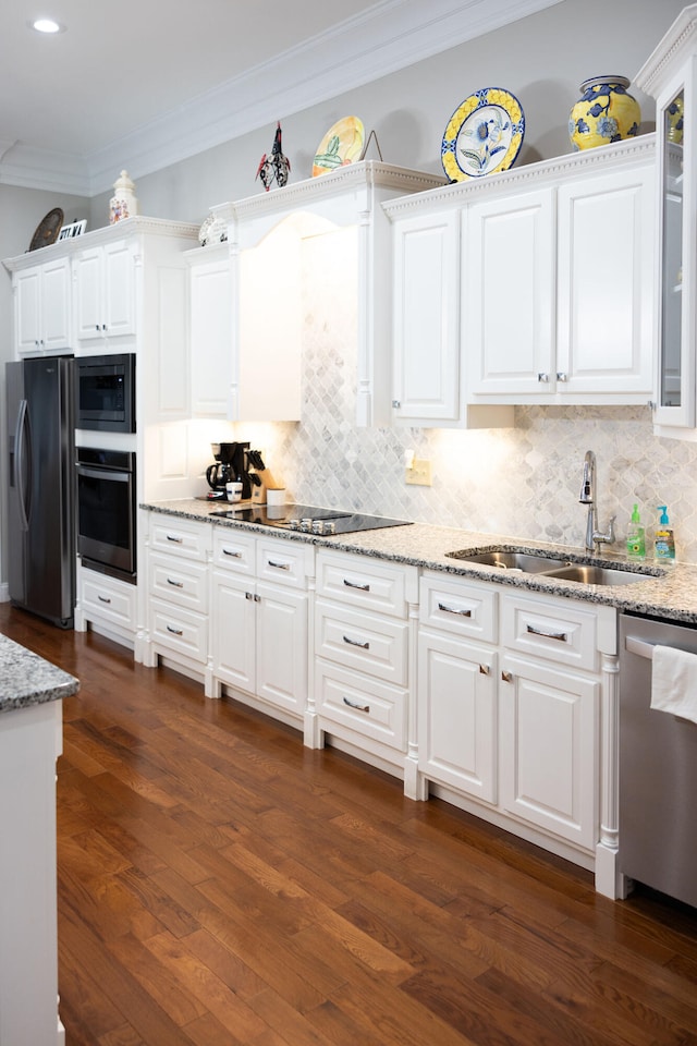 kitchen featuring appliances with stainless steel finishes, white cabinets, sink, and dark hardwood / wood-style flooring