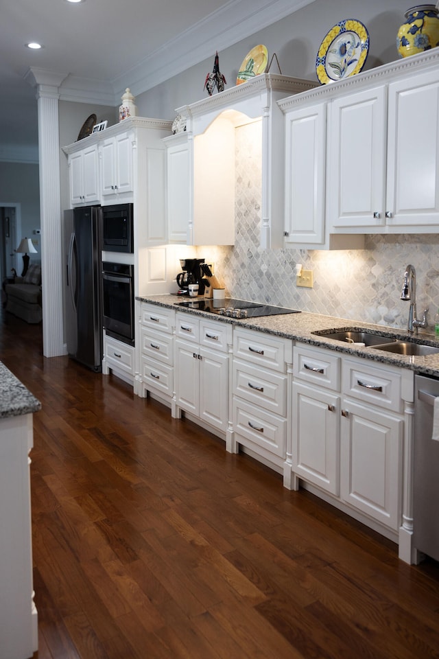 kitchen with dark hardwood / wood-style flooring, appliances with stainless steel finishes, sink, and white cabinets