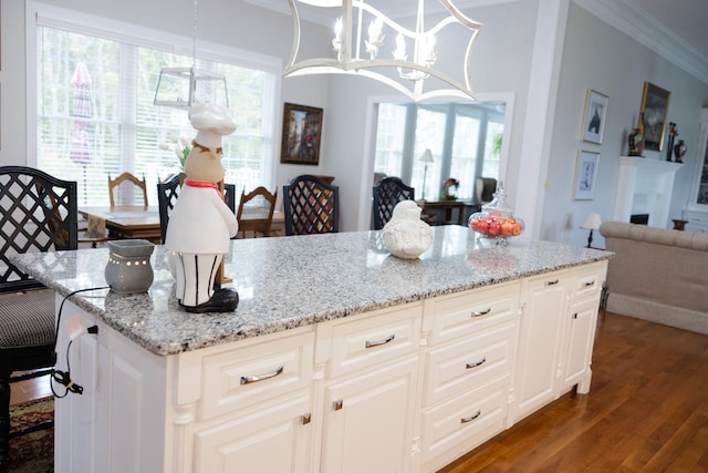 kitchen with dark wood-type flooring, decorative light fixtures, and a healthy amount of sunlight