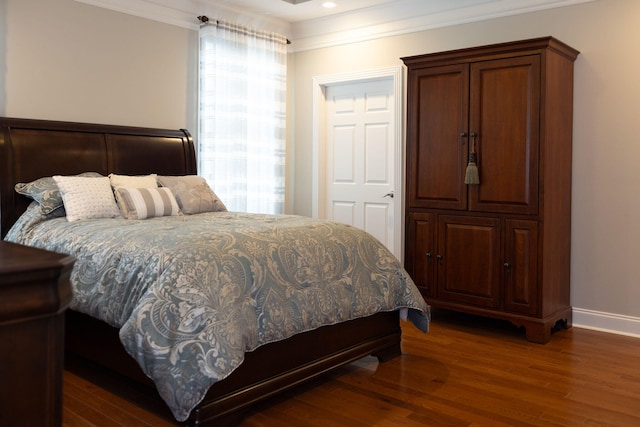 bedroom featuring ornamental molding and dark hardwood / wood-style flooring