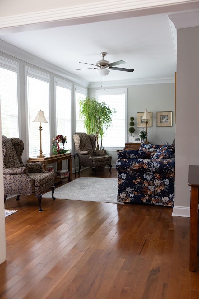 living room with dark wood-type flooring, crown molding, and ceiling fan