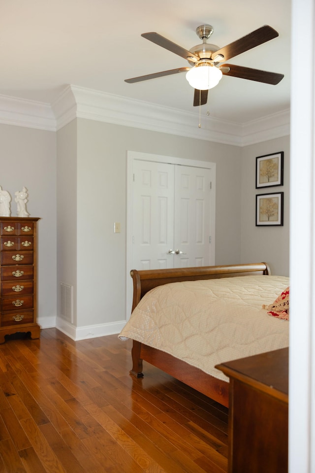 bedroom featuring a closet, ceiling fan, crown molding, and dark hardwood / wood-style floors