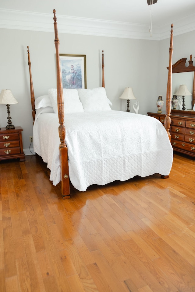 bedroom with hardwood / wood-style flooring and ornamental molding