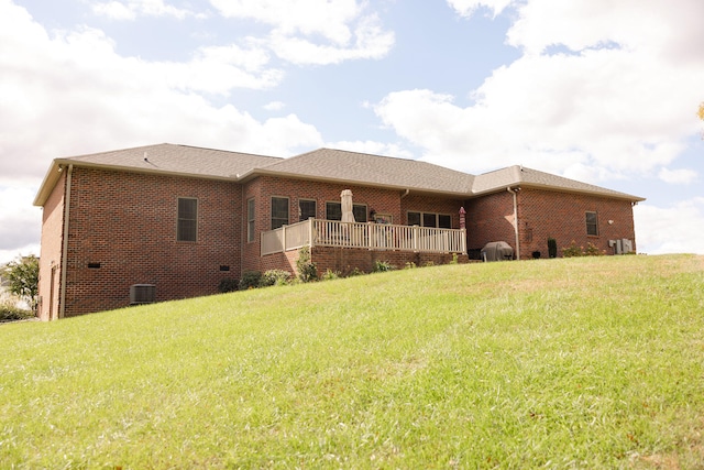 rear view of property featuring central air condition unit and a yard