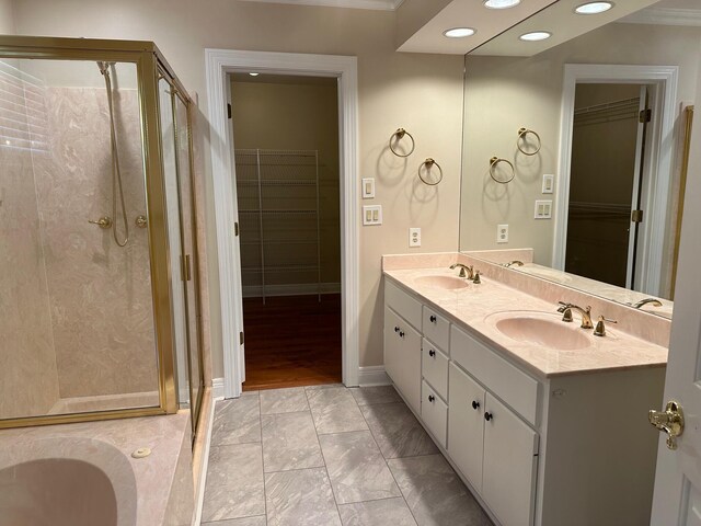 bathroom with tile patterned flooring, vanity, a bath, and ornamental molding