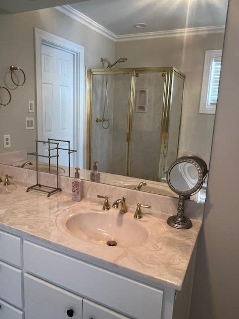 bathroom featuring crown molding, vanity, and a shower with shower door