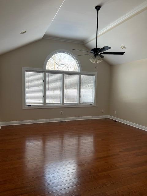 unfurnished room with ceiling fan, dark wood-type flooring, and lofted ceiling