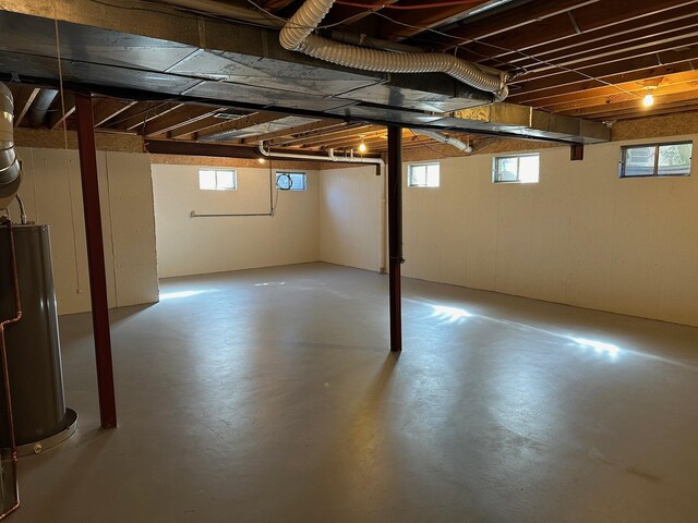 basement featuring plenty of natural light and water heater