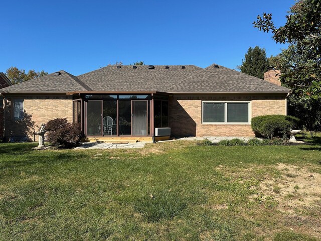 back of property with a sunroom and a yard