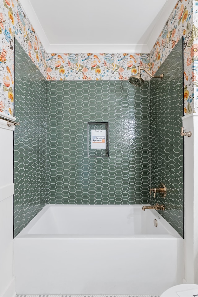 bathroom featuring toilet and tiled shower / bath