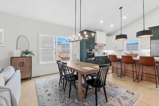 dining room with lofted ceiling and light wood-type flooring