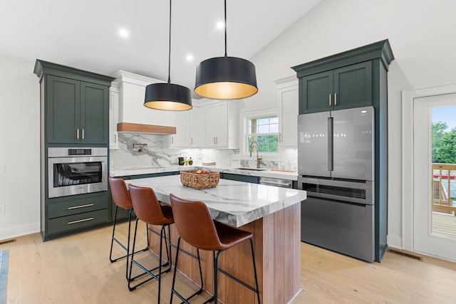 kitchen featuring a healthy amount of sunlight, appliances with stainless steel finishes, a center island, and pendant lighting