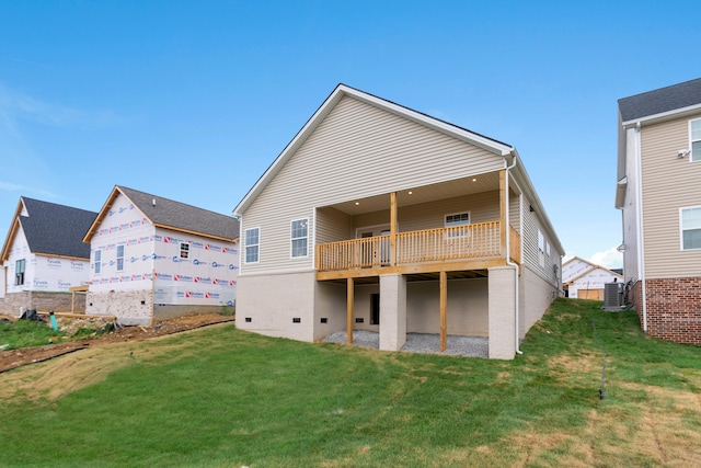 rear view of house featuring central AC and a lawn