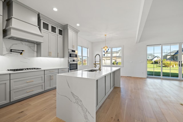 kitchen featuring sink, appliances with stainless steel finishes, custom range hood, and a healthy amount of sunlight