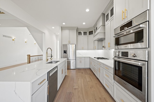 kitchen featuring white cabinetry, light hardwood / wood-style flooring, appliances with stainless steel finishes, and sink