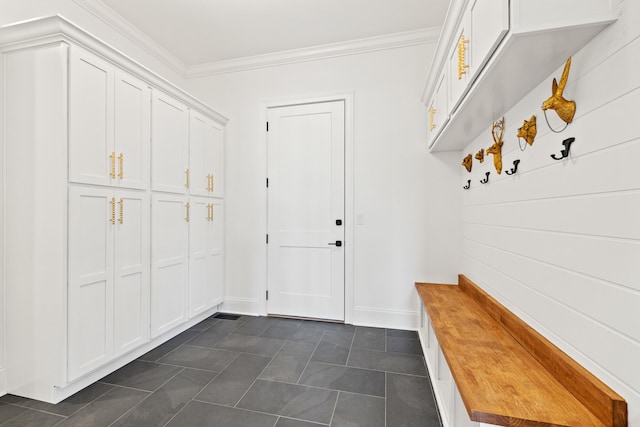 mudroom featuring crown molding and dark tile patterned floors