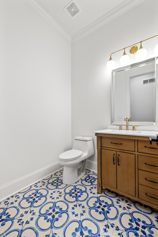 bathroom with toilet, crown molding, vanity, and tile patterned flooring