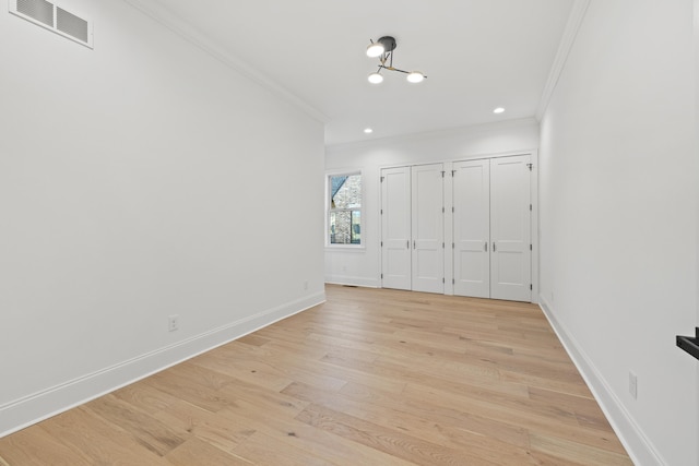 unfurnished bedroom featuring crown molding and light wood-type flooring