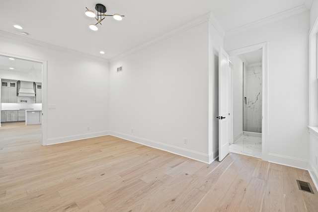 spare room featuring light hardwood / wood-style floors and crown molding