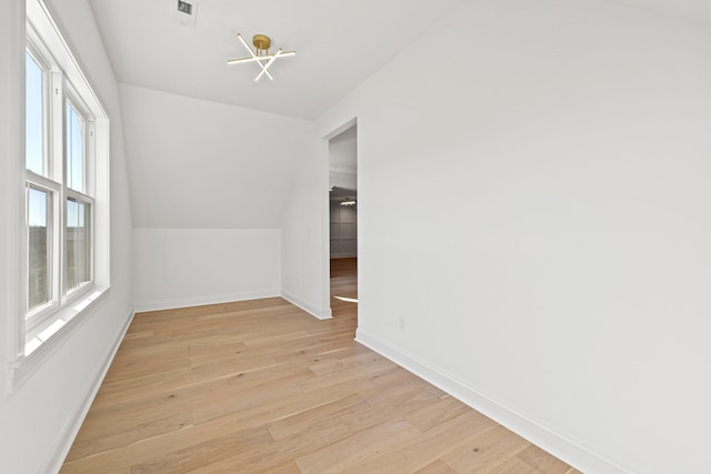 additional living space featuring light hardwood / wood-style flooring and lofted ceiling