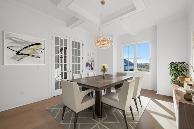 dining room featuring a chandelier, ornamental molding, dark wood-type flooring, french doors, and coffered ceiling