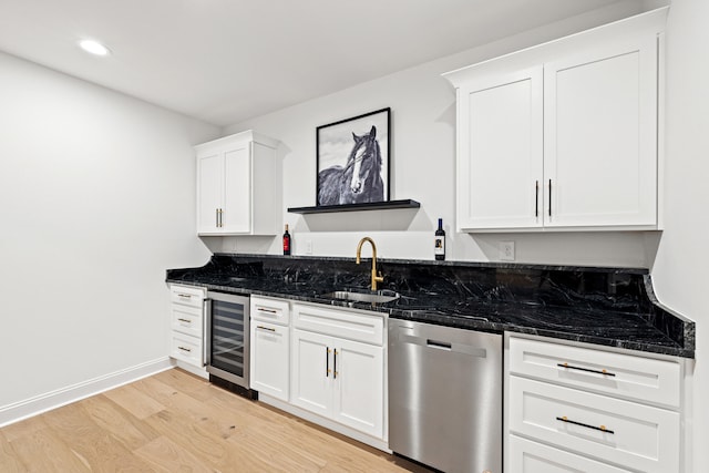 kitchen with sink, dishwasher, light hardwood / wood-style floors, dark stone countertops, and wine cooler