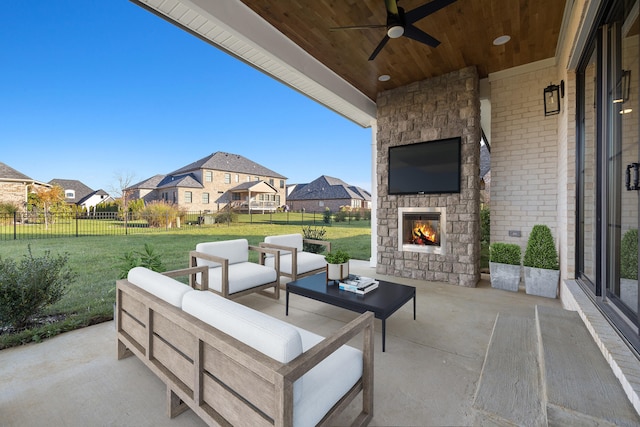 view of patio with an outdoor living space with a fireplace and ceiling fan