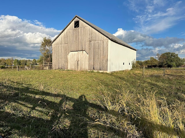 view of outdoor structure featuring a lawn and a rural view