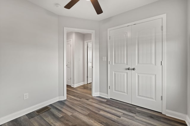 unfurnished bedroom featuring dark wood-type flooring, ceiling fan, and a closet