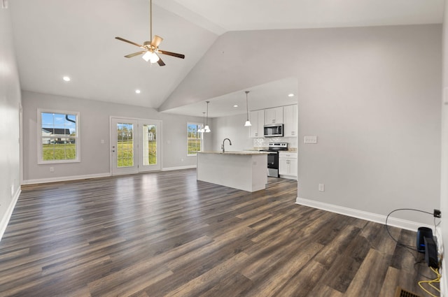 unfurnished living room featuring ceiling fan, high vaulted ceiling, sink, and dark wood-type flooring