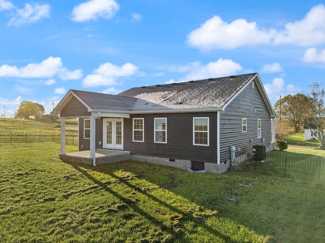 back of house with a lawn, french doors, a patio area, and central AC