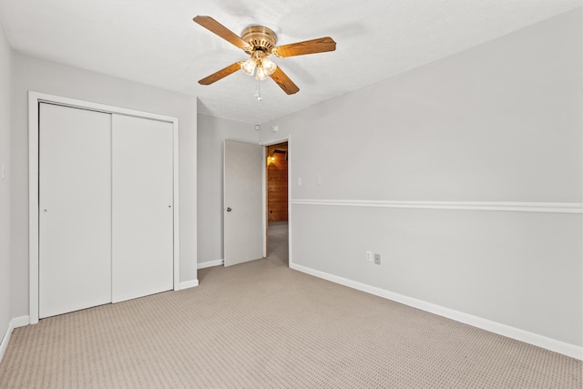 unfurnished bedroom with a closet, ceiling fan, and light colored carpet