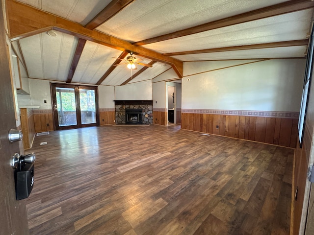 unfurnished living room featuring ceiling fan, lofted ceiling with beams, dark hardwood / wood-style floors, and wood walls