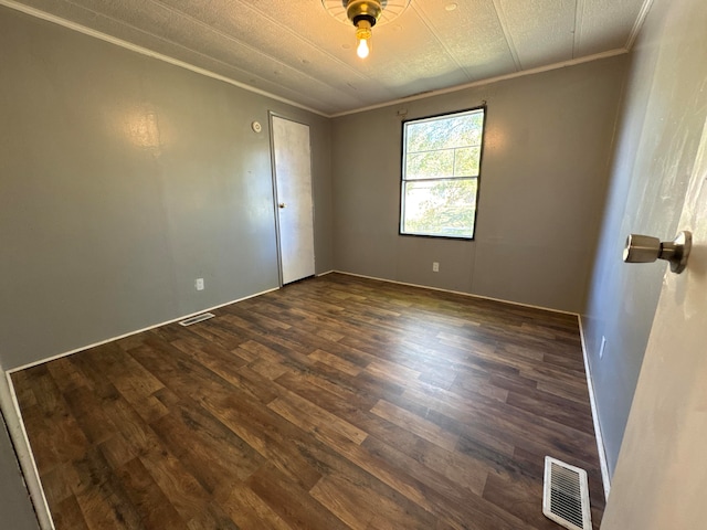 empty room featuring crown molding and dark hardwood / wood-style floors