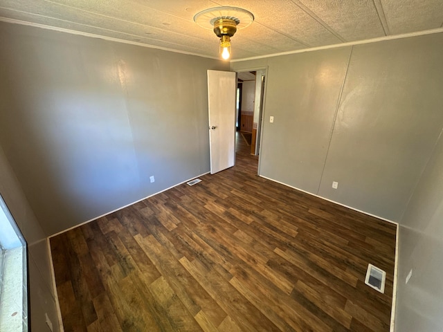 unfurnished room with a textured ceiling and dark hardwood / wood-style floors