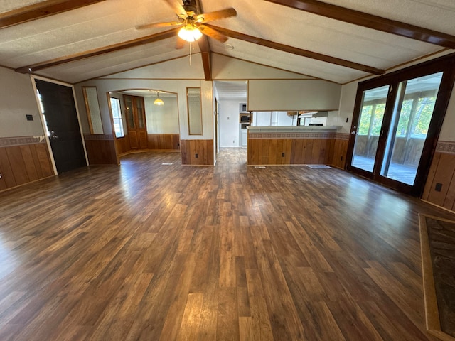 unfurnished living room with vaulted ceiling with beams, dark hardwood / wood-style floors, a textured ceiling, and ceiling fan