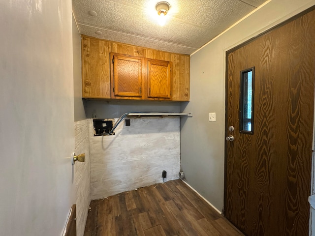 laundry area with dark hardwood / wood-style flooring and cabinets