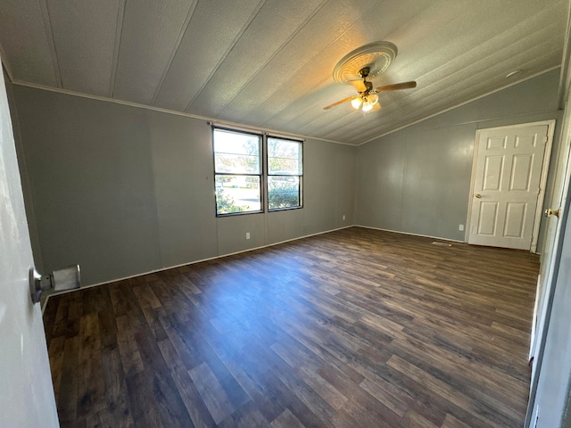 empty room featuring lofted ceiling, dark hardwood / wood-style floors, crown molding, and ceiling fan