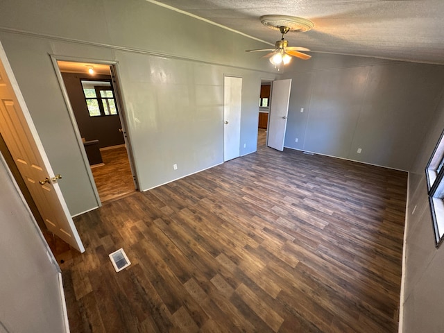 interior space featuring ceiling fan, a textured ceiling, lofted ceiling, and dark hardwood / wood-style flooring