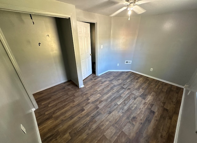 unfurnished bedroom with ceiling fan and dark hardwood / wood-style flooring