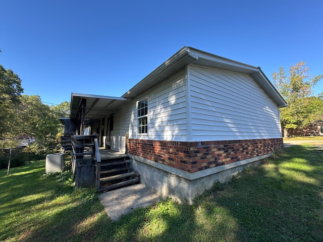 view of side of home with a yard and central AC unit