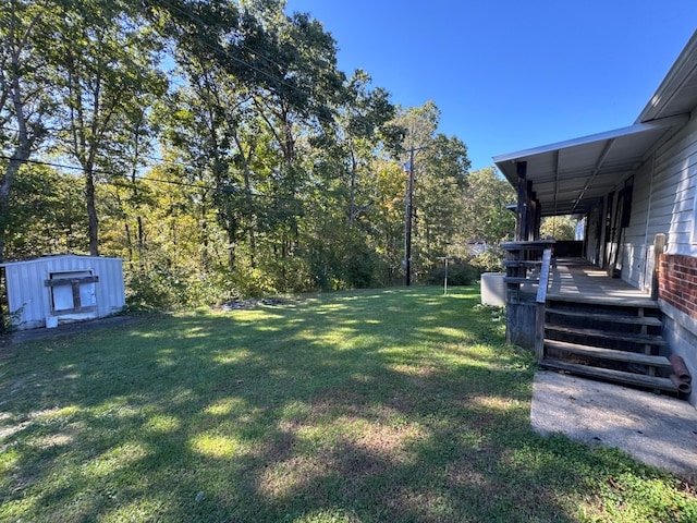 view of yard featuring a storage unit and a wooden deck