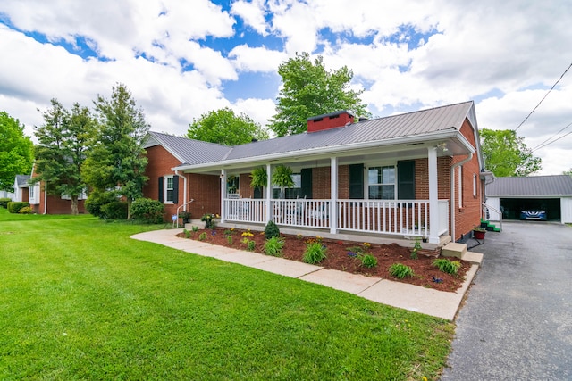 single story home with a porch, a front yard, and a garage