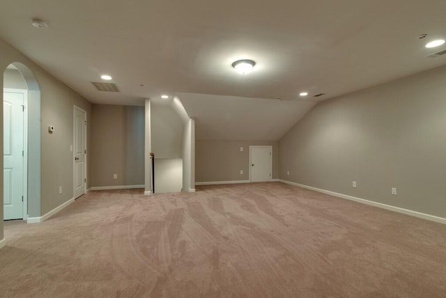 bonus room with light carpet and vaulted ceiling